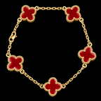 A gold chain bracelet featuring five red enameled four-leaf clover motifs with beaded gold borders, displayed against a solid black background.