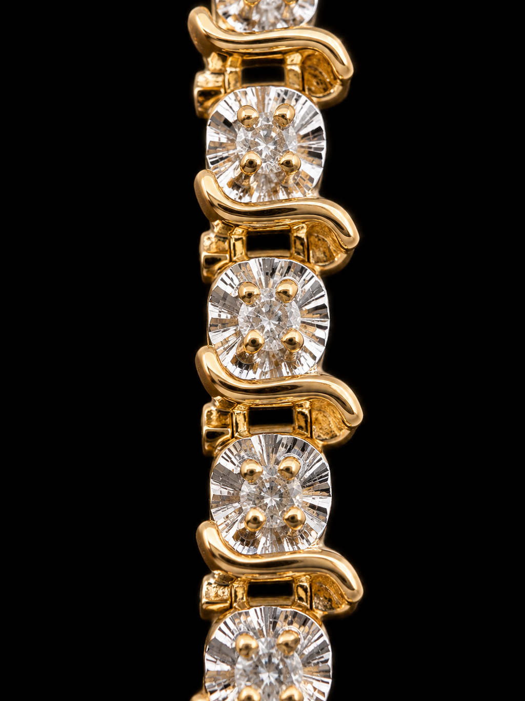 A close-up of a yellow gold tennis bracelet featuring oval-cut diamonds in a wavy, linked design against a solid black background.